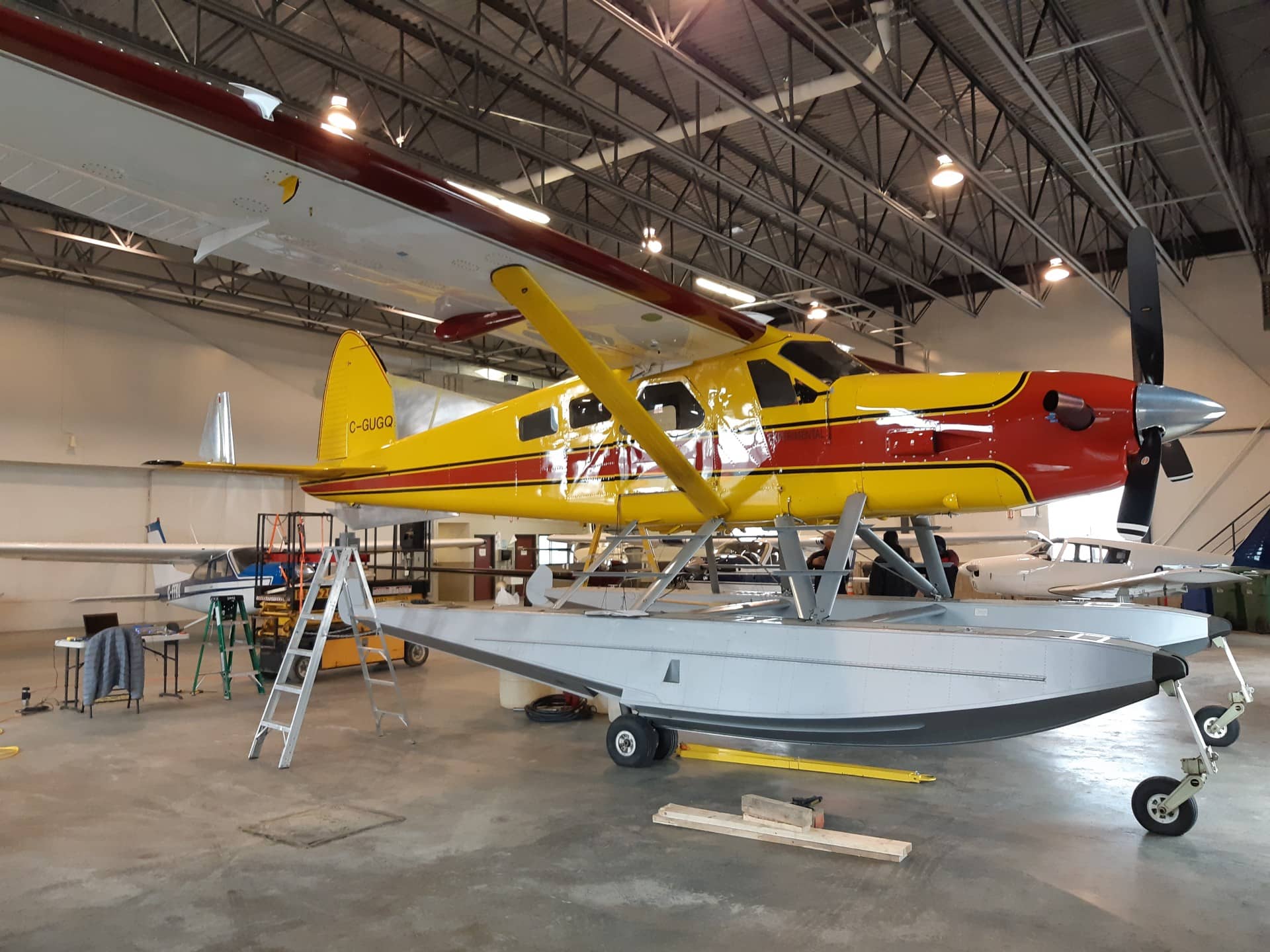 A yellow and red plane inside a garage